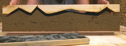 Retrait du moule sculpté d&#039;un prototype de bloc en terre crue lors de la phase de recherche ©amàco