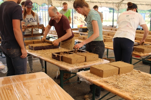 Réalisation des briques en terre crue par des bénévoles — ©amàco
