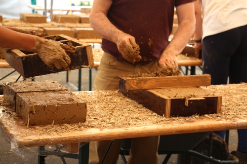 Réalisation des briques en terre crue par des bénévoles — ©amàco